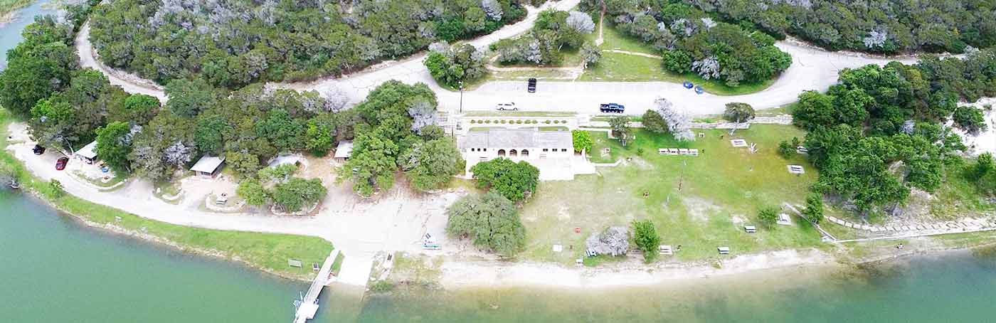 Aerial view of a lakeside recreational area featuring a building with arch windows.