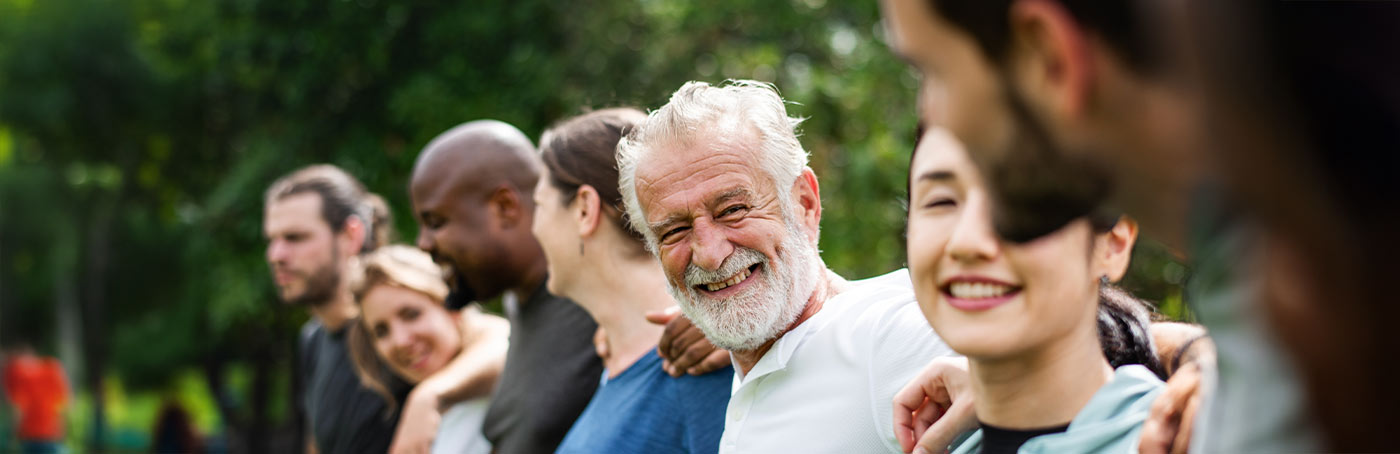 A group of people standing together with an older man smiling