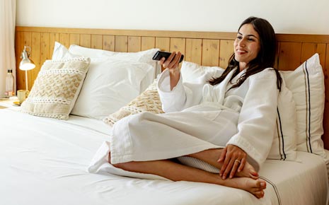 Woman sitting on a hotel bed